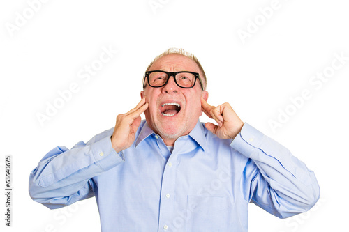Fotografie Loud noises. Annoyed old man covers his ears, tired of neighbor