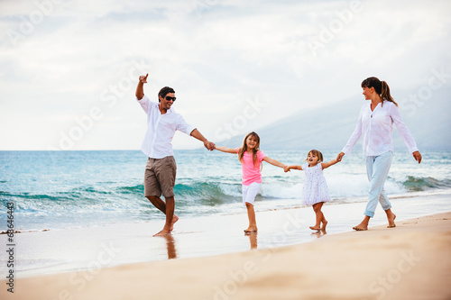Happy young family walking on the beach