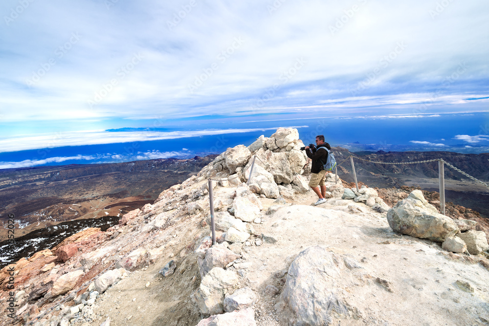 Man taking picture at top volcano Teide at Spring