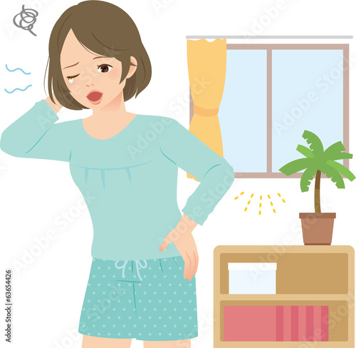 朝の室内で眠そうにあくびする若い女性
