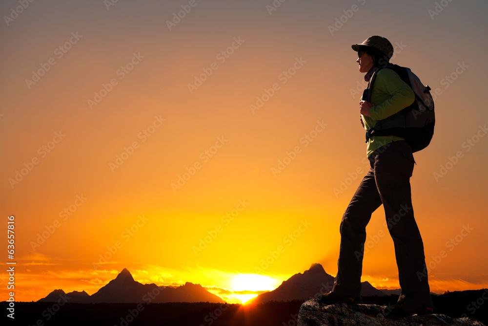 Silhouette of female hiker at sunset.