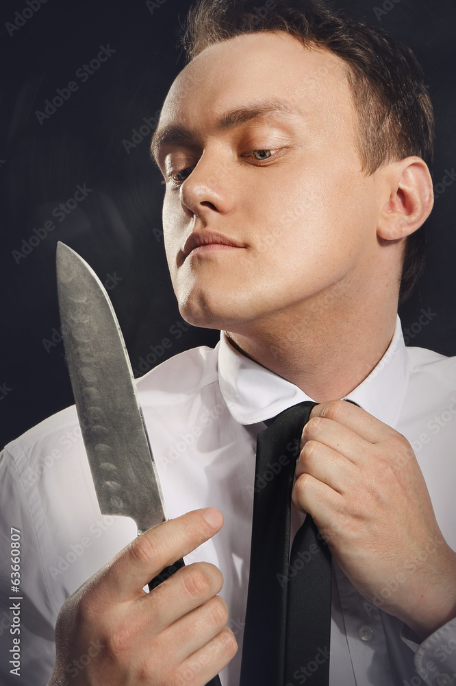 Portret  młodego człowieka przeglądającego się w ostrzu noża. - obrazy, fototapety, plakaty 