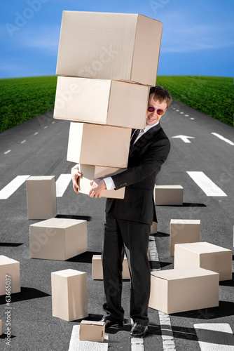 Business man holding carton boxes on the road photo