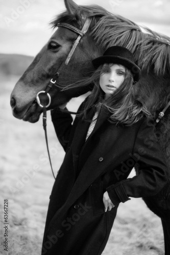 black and white portrait of beautiful girl near to a horse