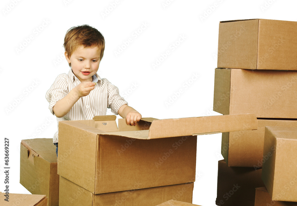 little boy plays in boxes