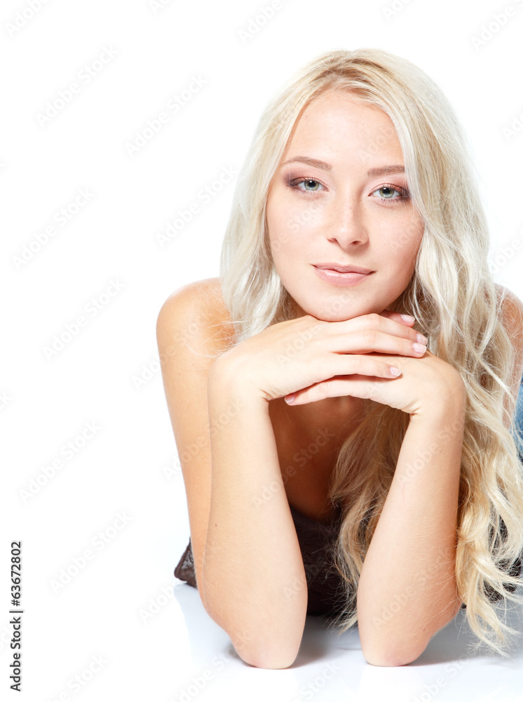 Beautiful blond young woman lying and looking at camera. Isolate
