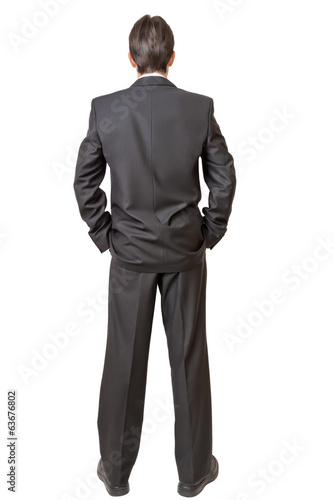 Backside of man in black suit keeping hands in pockets