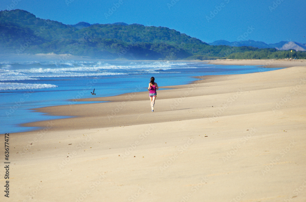 Woman running on beach, beautiful girl runner jogging outdoors