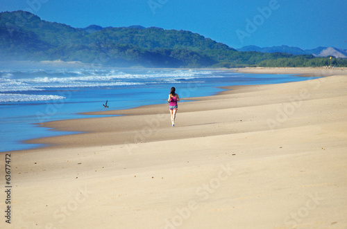 Woman running on beach, beautiful girl runner jogging outdoors