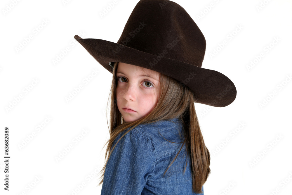 young cowgirl looking over her shoulder with a somber look