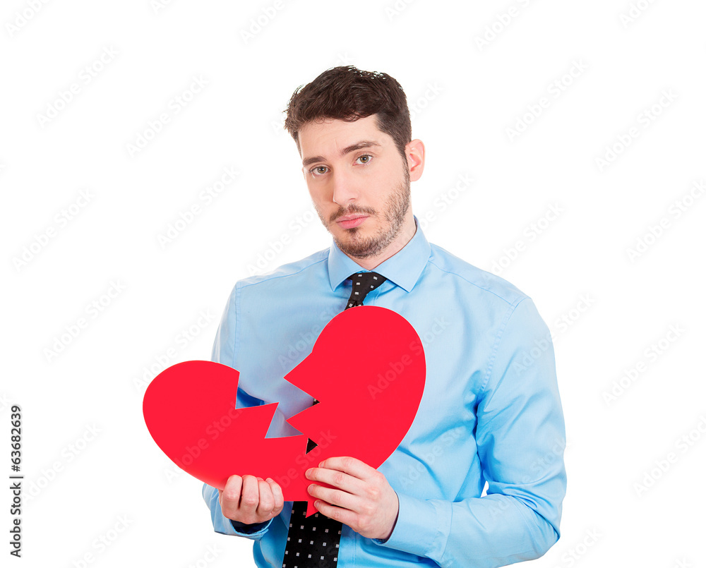 Heartbroken man holds pieces of red heart, on white background Heartbroken man holds pieces of red heart, on white background