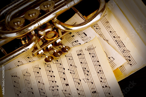 Photography Musical notes and trumpet on wooden table