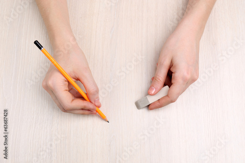 Human hands with pencil and erase rubber