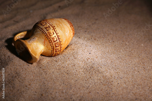 Billede på lærred Greek ceramic amphora on sand, close up