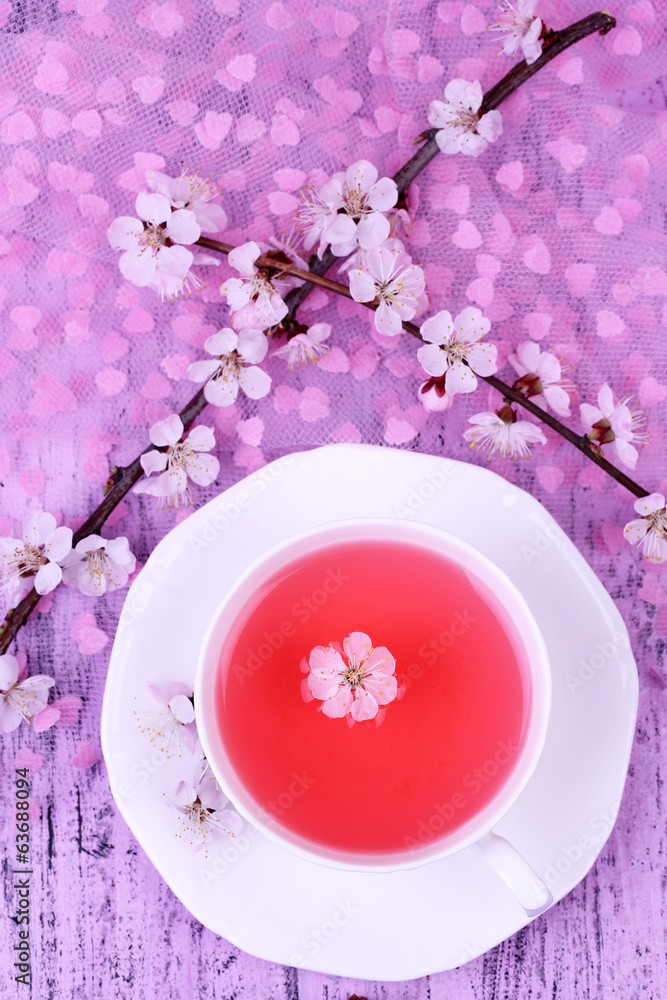 Fragrant tea with flowering branches on wooden table close-up Fragrant tea with flowering branches on wooden table close-up