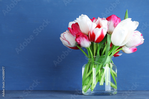 Fototapeta Naklejka Na Ścianę i Meble -  Beautiful tulips in glass jug on color wooden background