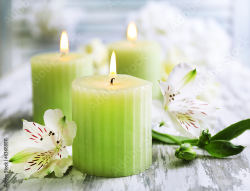 Beautiful candles with flowers on wooden background