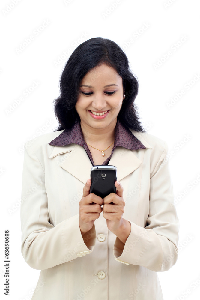 Happy young Indian business woman text messaging against white Happy young Indian business woman text messaging against white