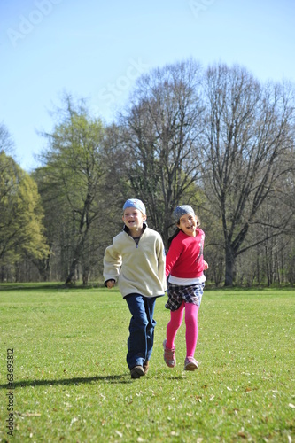 Boy and girl are running on the grass