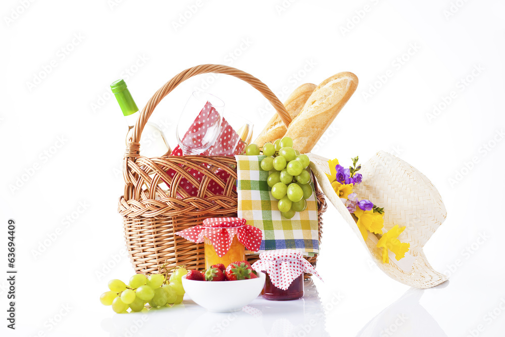picnic basket with wine, fruits and summer hat isolated on white