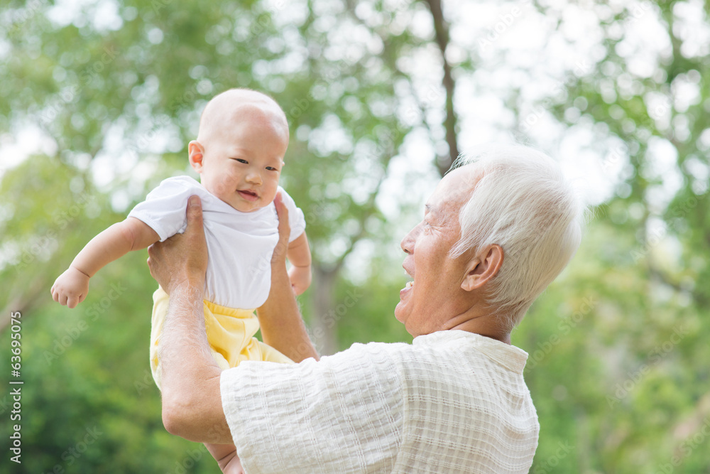 Fototapeta premium Asian grandfather carrying grandson