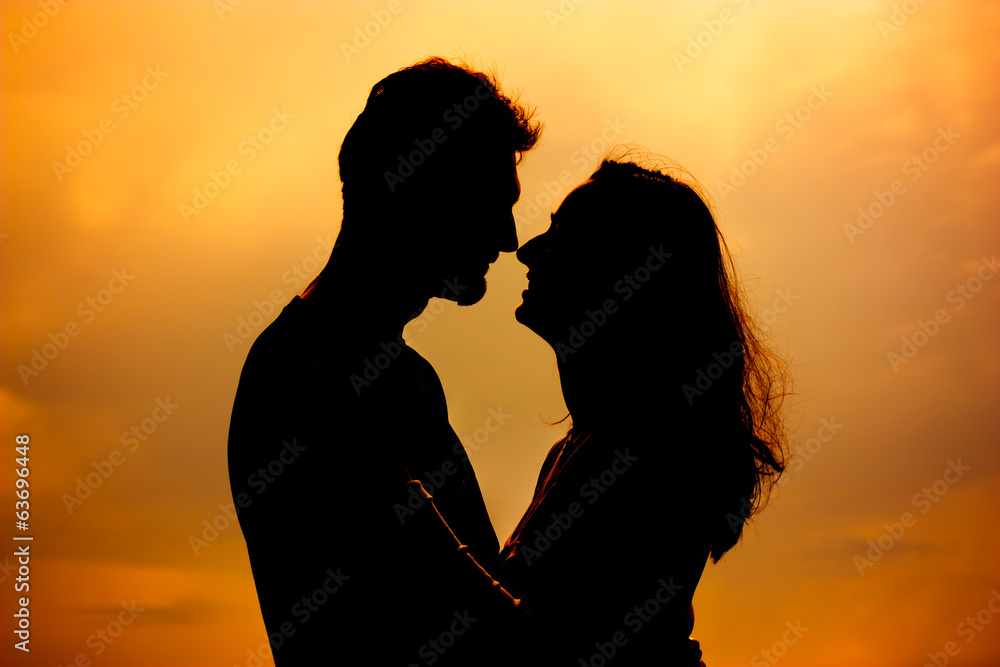 Young couple silhouette, dating, orange background