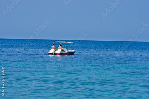 Couple driving a pedal boat on a vacation at Aegean sea
