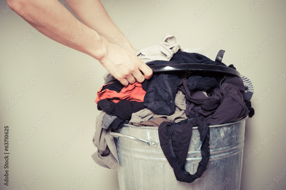 Woman sorting out her laundry - obrazy, fototapety, plakaty 
