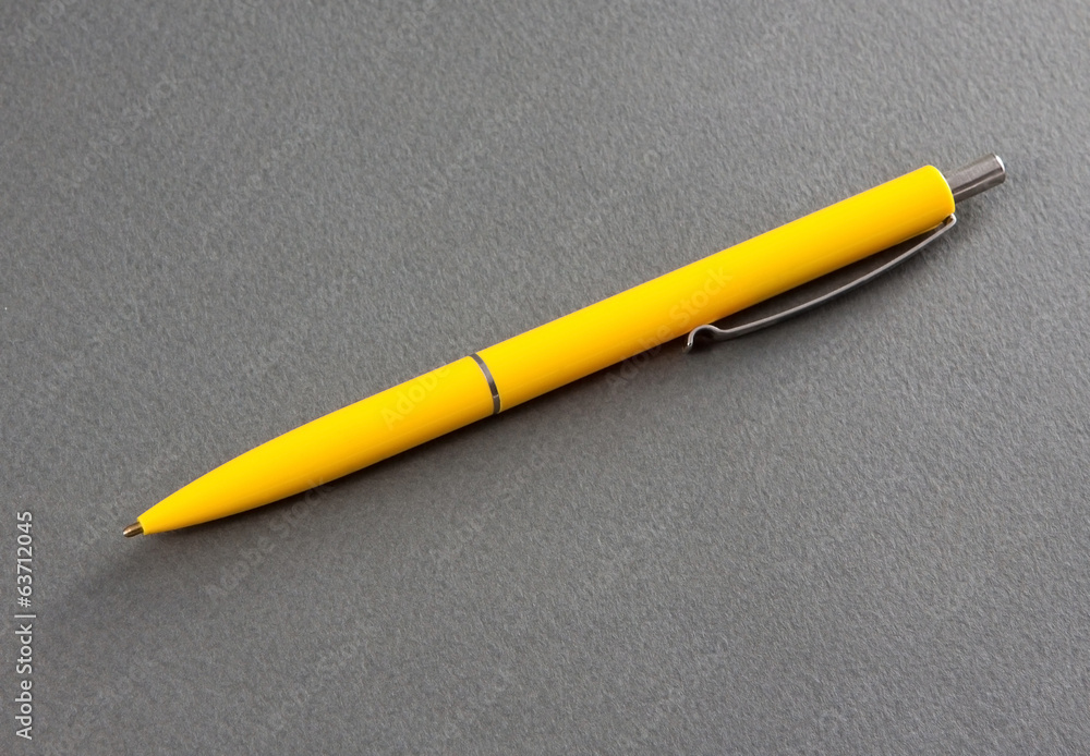 Yellow pen on a gray background.