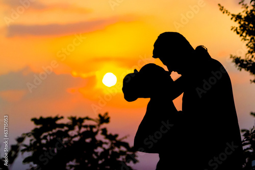 BRIDE AND GROOM KISS SUNSET