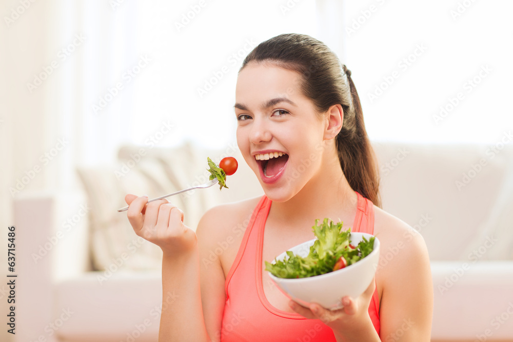 smiling teenage girl with green salad at home smiling teenage girl with green salad at home