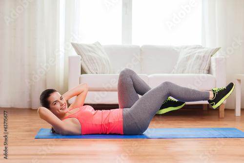 smiling girl doing exercise on floor at home