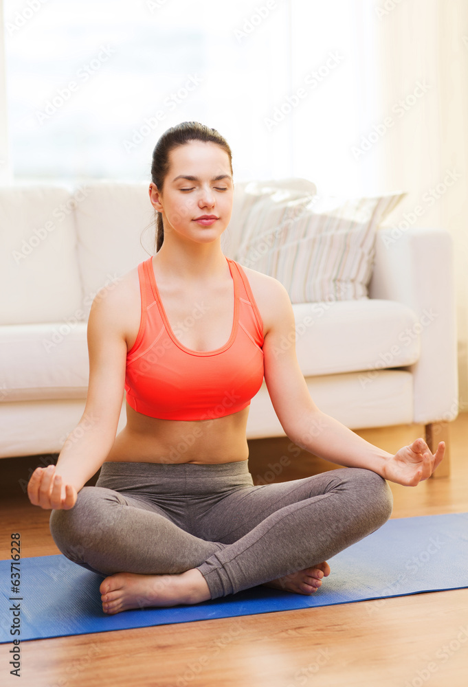 smiling teenager meditating at home smiling teenager meditating at home