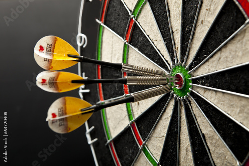 Three darts in bullseye of dartboard