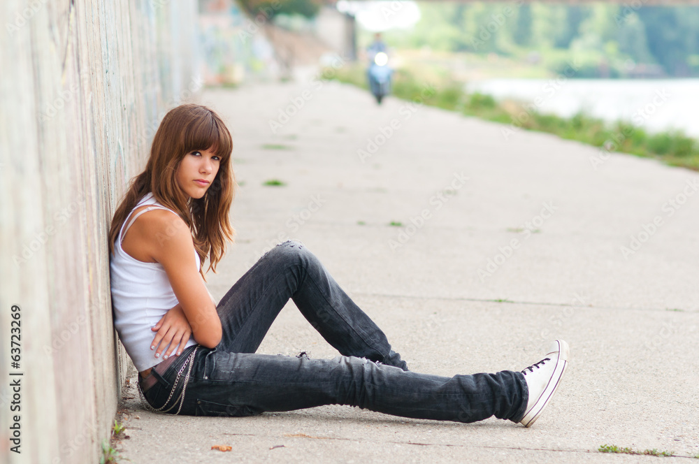 Sad teenage girl sitting alone Sad teenage girl sitting alone