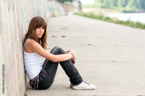 Sad teenage girl sitting alone