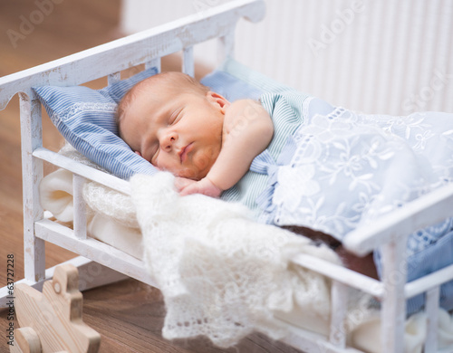 newborn baby in a small bed