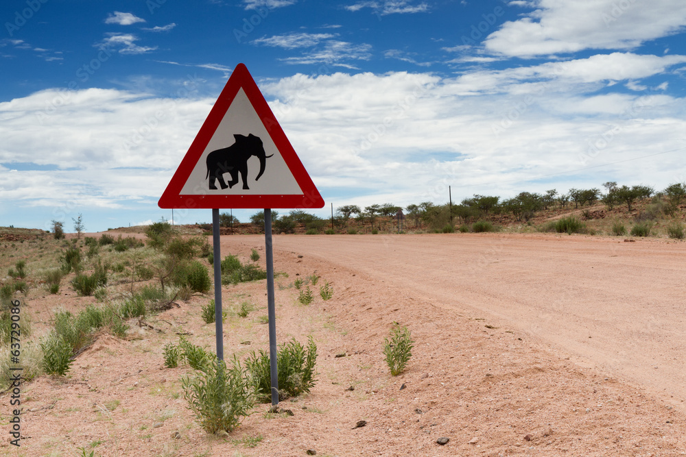 Elephant crossing sign on a gravel road