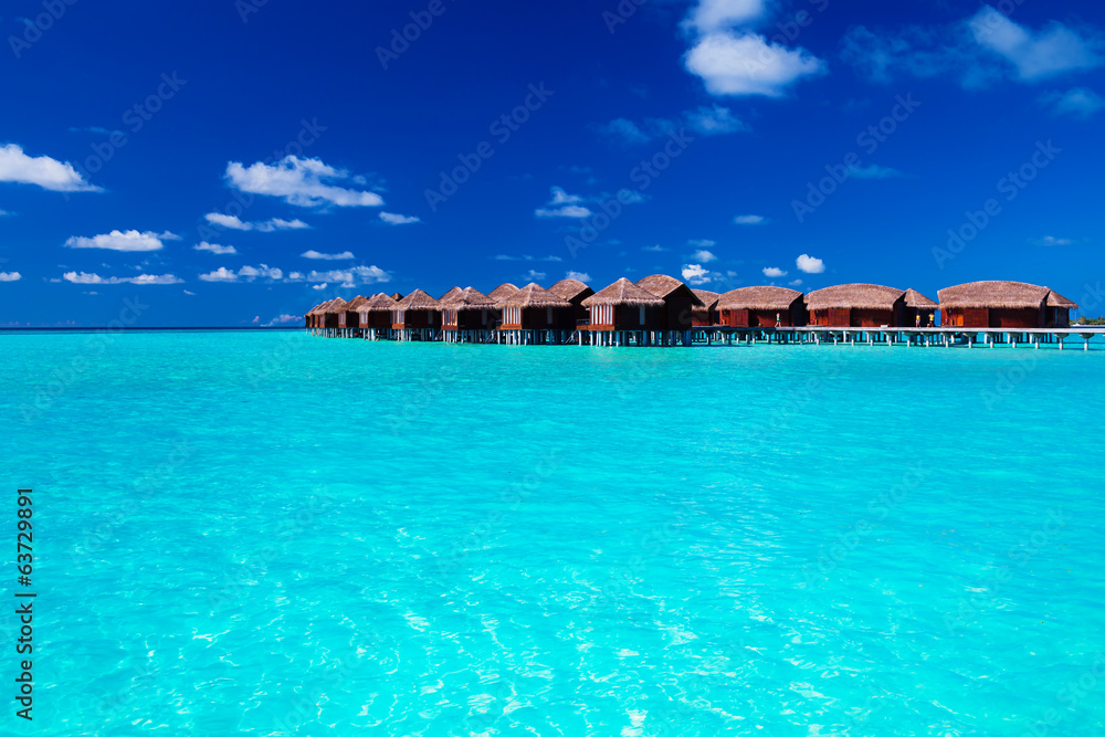 Overwater villas in blue tropical lagoon