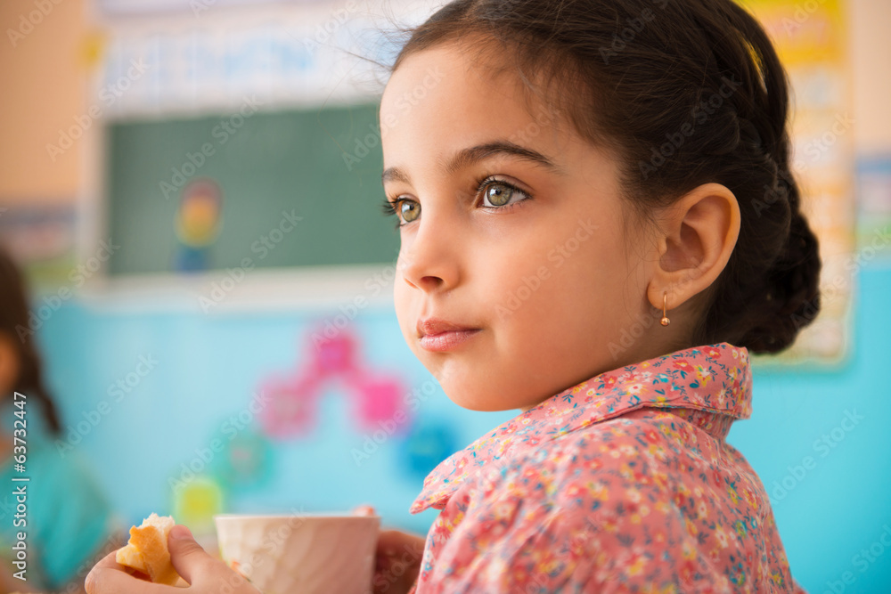 © spass - Cute hispanic girl with cup of milk at daycare © spass - Cute hispanic girl with cup of milk at daycare
