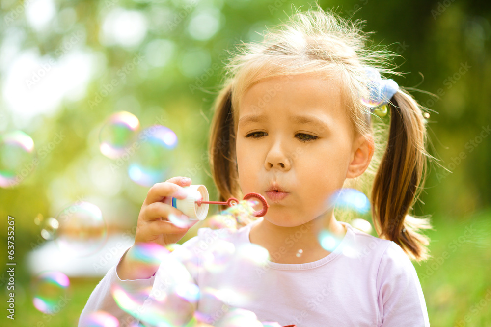 Little girl is blowing a soap bubbles Little girl is blowing a soap bubbles