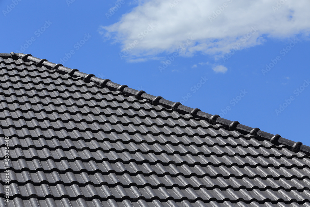 black tiles roof on a new house with blue sky black tiles roof on a new house with blue sky
