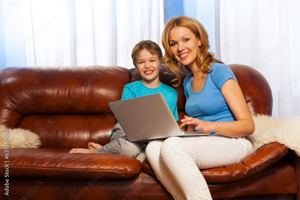 Laughing child and smiling mum with laptop Laughing child and smiling mum with laptop
