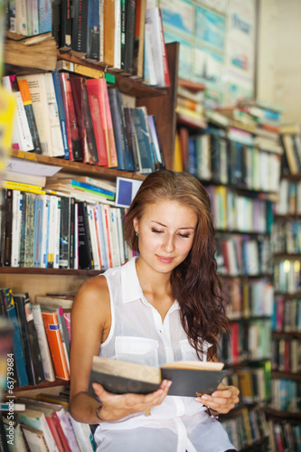 Woman reading a book in library