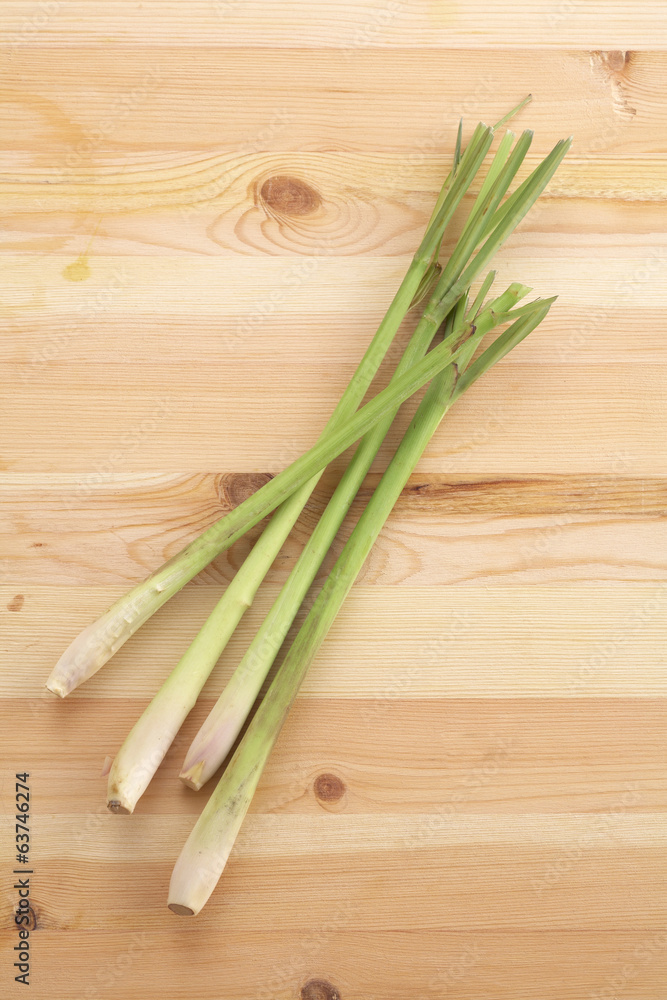 four lemongrass on wooden table in sun light four lemongrass on wooden table in sun light