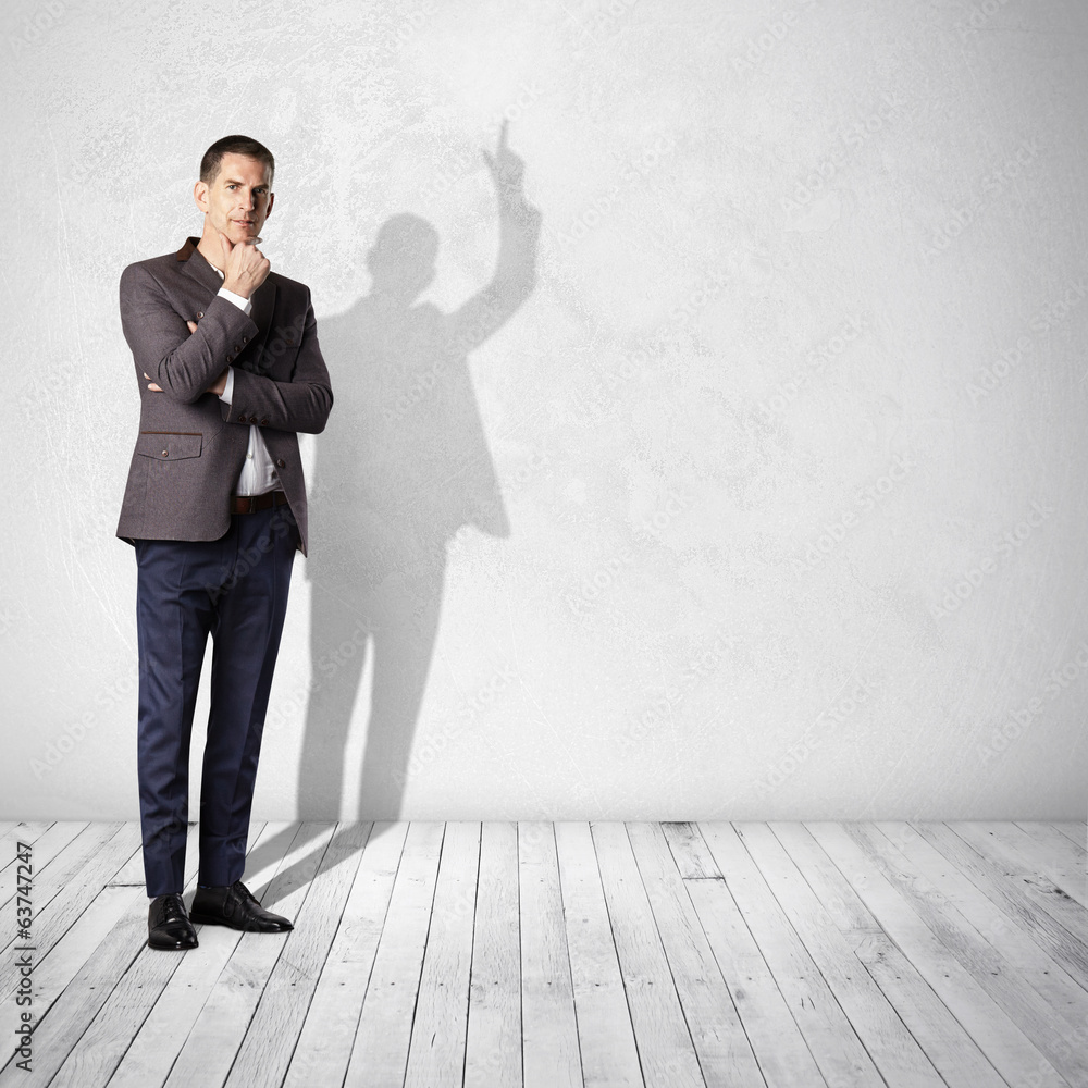 thoughtful businessman and his shadow showing up thoughtful businessman and his shadow showing up