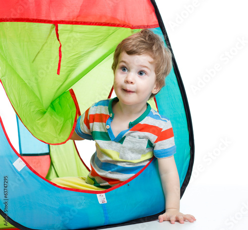 little boy playing in a tent