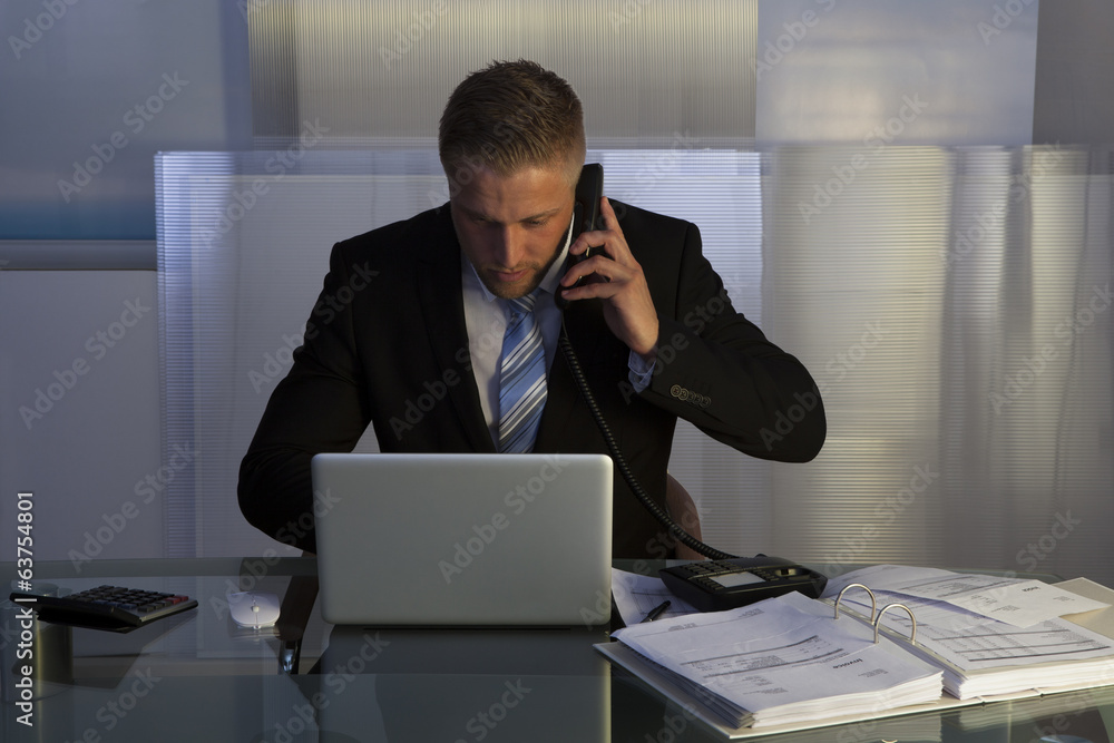 Stressed businessman working late into the night Stressed businessman working late into the night