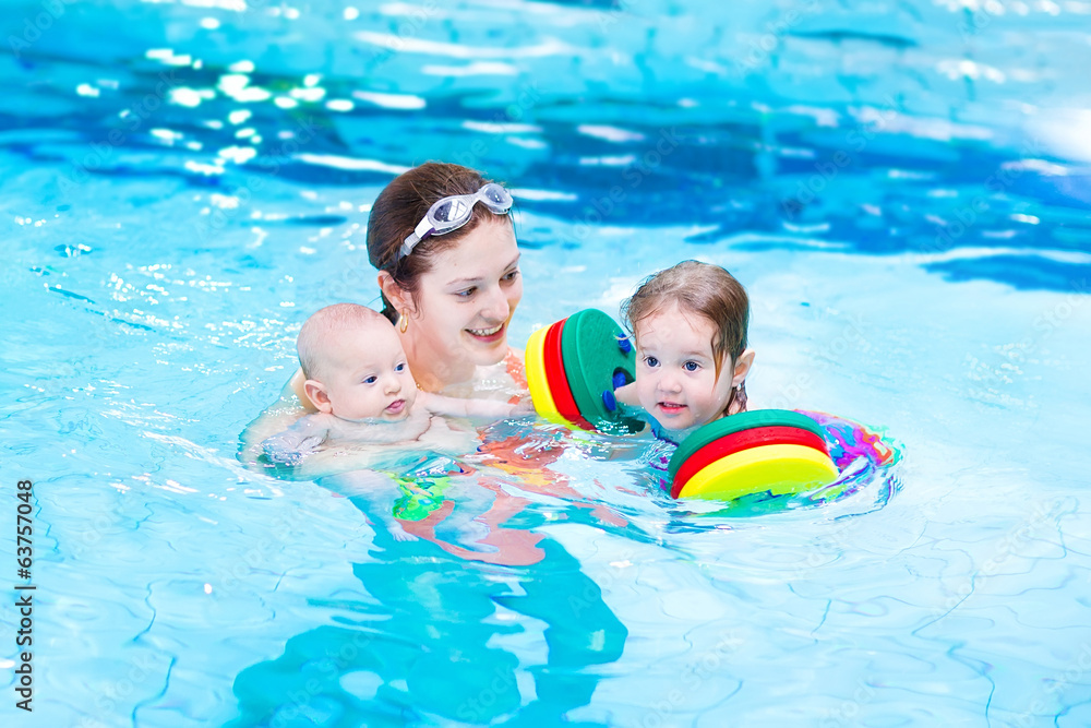 Young active mother swimming with toddler daughter and baby son Young active mother swimming with toddler daughter and baby son