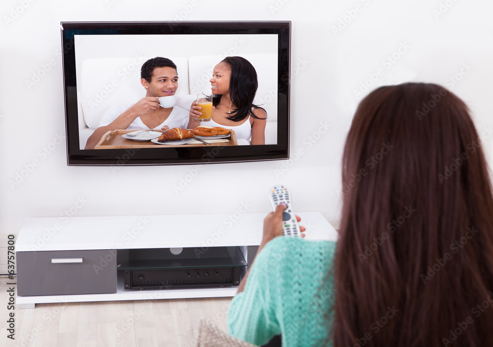 Woman Watching TV In Living Room - obrazy, fototapety, plakaty 